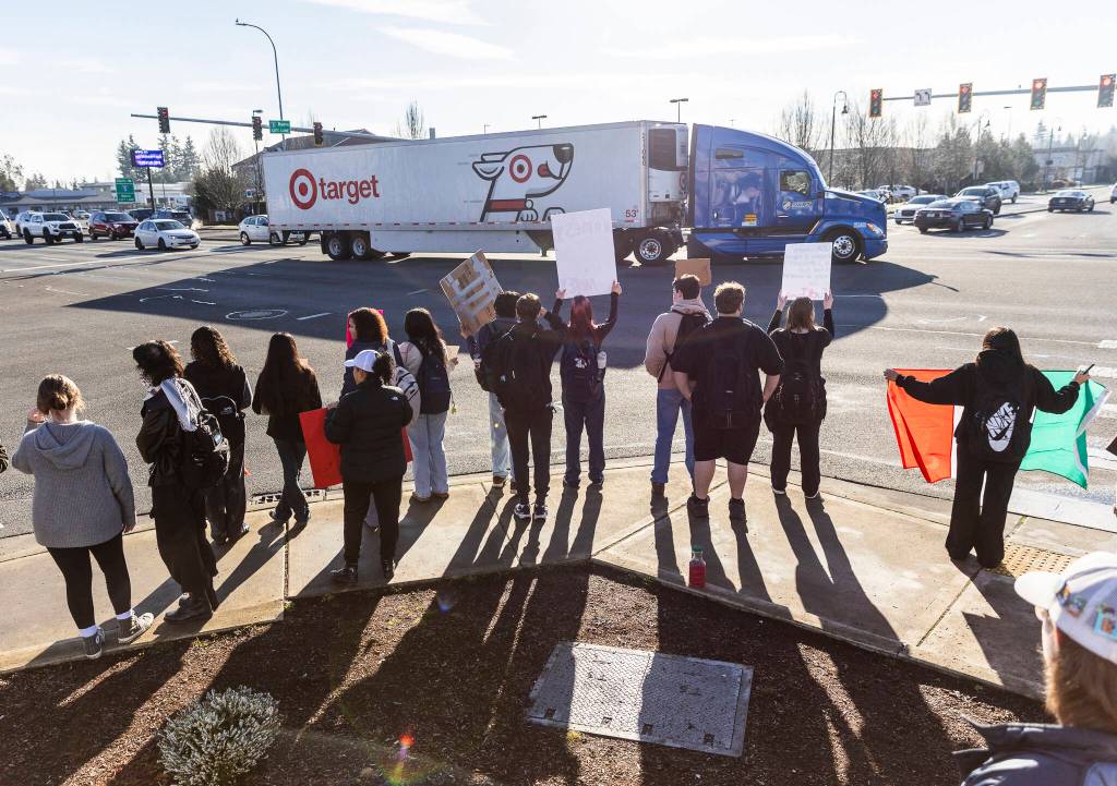 Students holds signs on the corner of 172nd Street Northeast and 27th Avenue Northeast during a student walkout and protest on Thursday, Feb. 5, 2026 in Lakewood, Washington. (Olivia Vanni / The Herald)