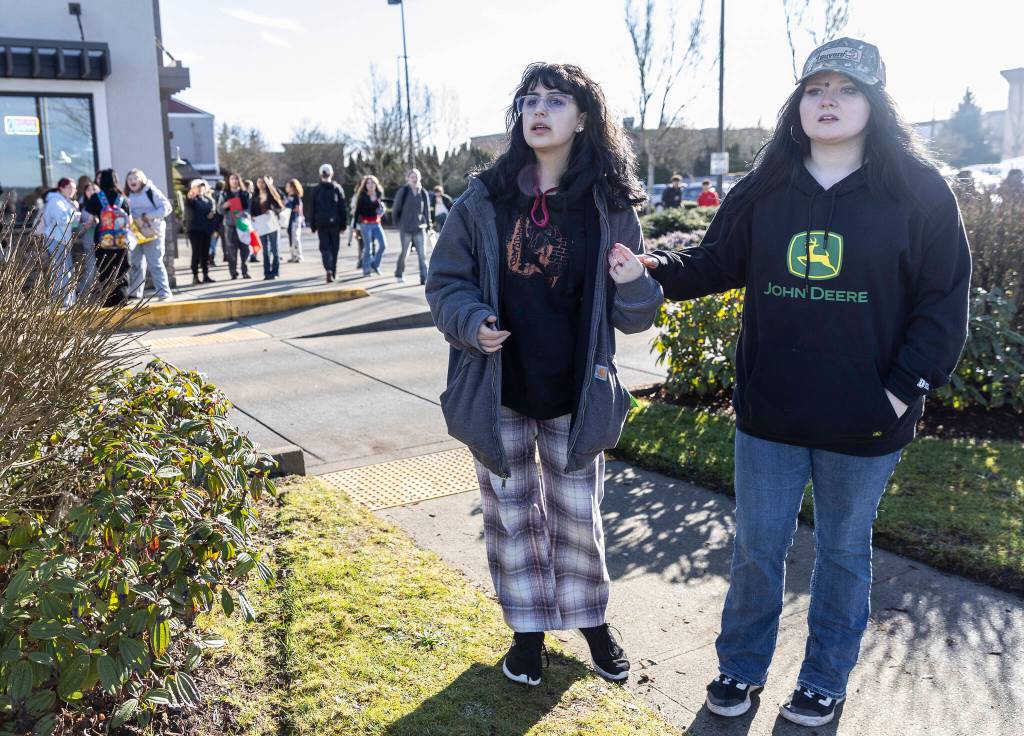 Students hold hands and look for friends as they retreat to a parking lot after a confrontation with a man during a student walkout and protest on Thursday, Feb. 5, 2026 in Marysville, Washington. (Olivia Vanni / The Herald)