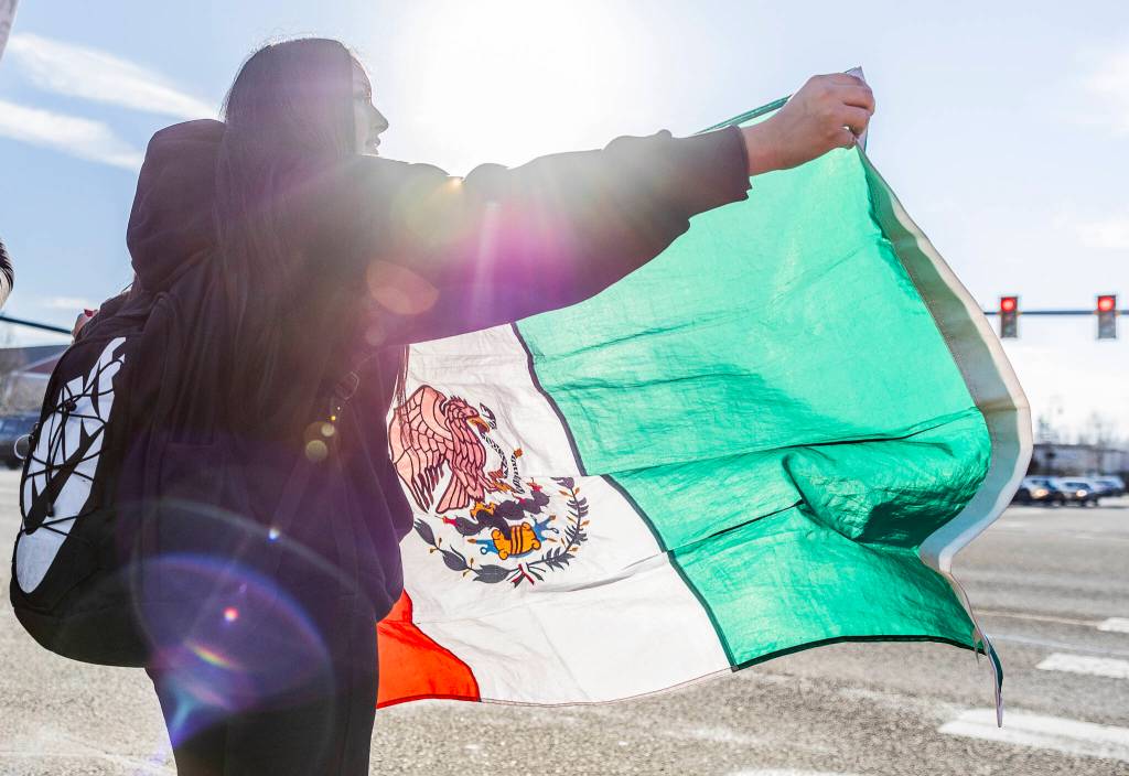 Jazmine Bustos, a sophomore at Lakewood High School, waves a Mexican flag during a student walkout and protest on Thursday, Feb. 5, 2026 in Marysville, Washington. (Olivia Vanni / The Herald)