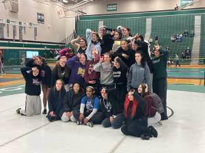 Lake Stevens girls wrestling poses with the District 1 4A Championship trophy on the podium at Jackson High School on Feb. 6, 2026. (Joe Pohoryles/The Herald)