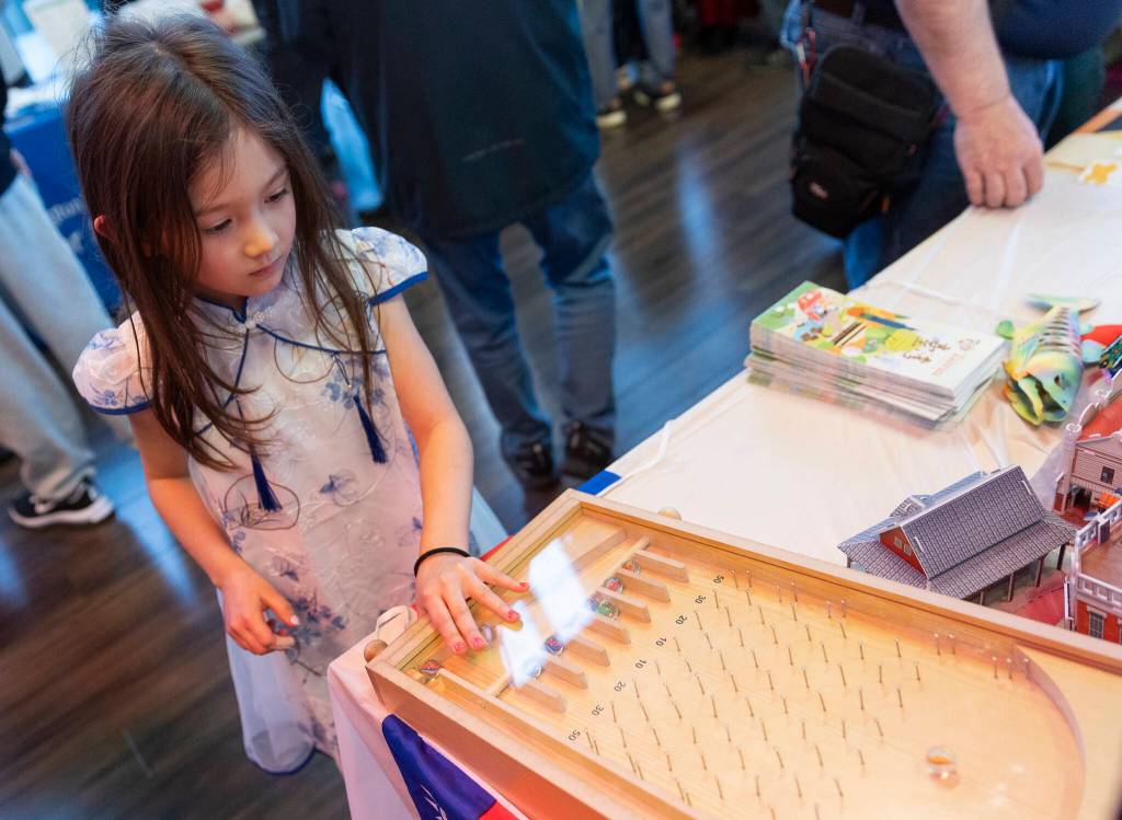 Kayda Barger, 7, plays Taiwanese pinball game during the City of Mukilteos Lunar New Year Celebration on Thursday in Mukilteo.