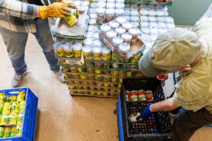 Charlie Laughtland, left, and Tim Brincefield, right, sort out cans of corn, pears and diced tomatoes at the Edmonds Food Bank on Wednesday, March 26, 2025 in Edmonds, Washington. (Olivia Vanni / The Herald)