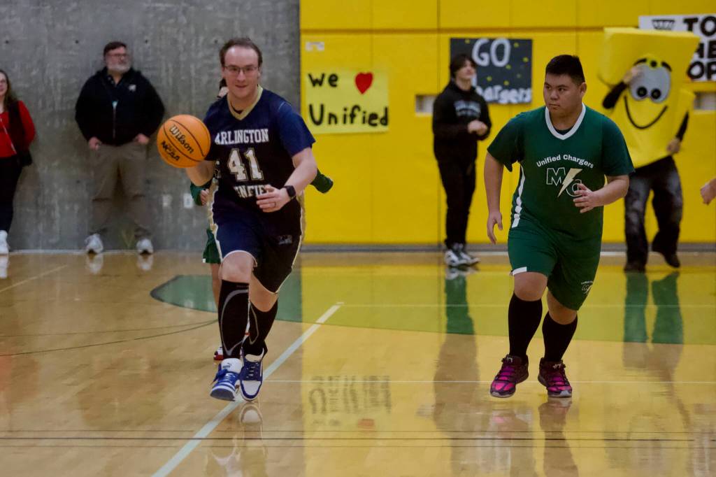 Arlingtons Devin Blumm (left) dribbles the ball up the court during the Eagles unified basketball game at Marysville Getchell High School on Feb. 9, 2026. (Joe Pohoryles/The Herald)