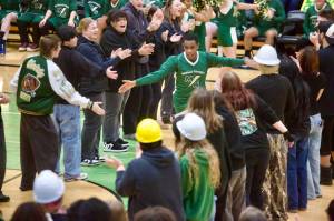 Marysville Getchell's Eyobed Angelo runs through a tunnel made up of his peers from the student section during the pregame introductions for the Chargers unified basketball game against Arlington at Marysville Getchell High School on Feb 9, 2026. (Joe Pohoryles/The Herald)