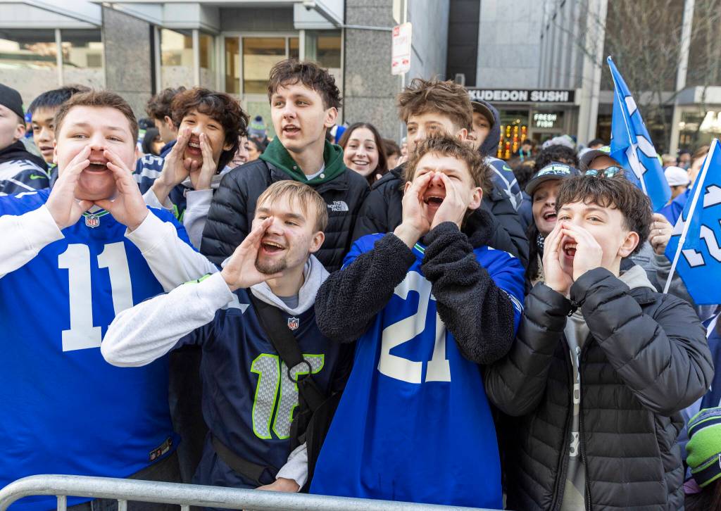 Simon Kurishko, Stas Demchuk, Artem Orlov, Max Demchuk, Jayden Nguyen, Alex Gubenya and Mark Shipachev, students from Mariner, Cascade and Kamiak high schools cheer during the Seahawks World Champions Parade on Wednesday, Feb. 11, 2026 in Seattle, Washington. (Olivia Vanni / The Herald)