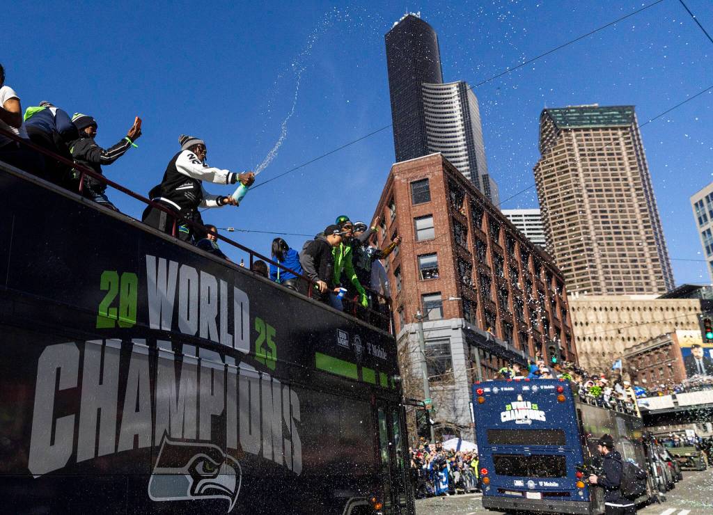 A Seahawks player sprays the crowd with champagne during the Seahawks World Champions Parade on Wednesday, Feb. 11, 2026 in Seattle, Washington. (Olivia Vanni / The Herald)