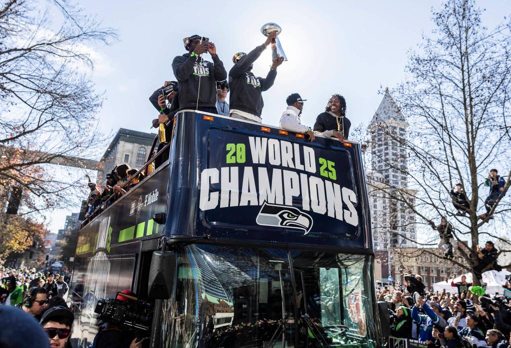 Seattle Seahawks Kenneth Walker III holds the Lombardi Trophy as their bus makes it way along 4th Avenue during the Seahawks World Champions Parade on Wednesday, Feb. 11, 2026, in Seattle, Washington. (Olivia Vanni / The Herald)