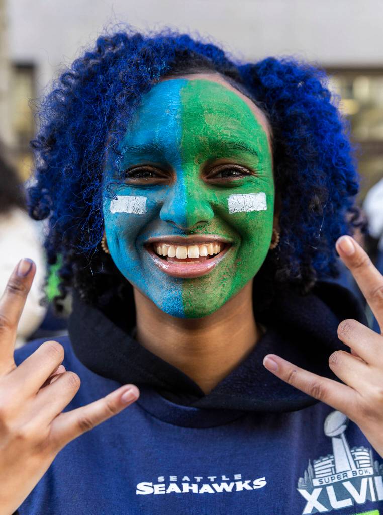 Sesen Kiflom smiles while wearing Seahawk colored faceprint during the Seahawks World Champions Parade on Wednesday, Feb. 11, 2026 in Seattle, Washington. (Olivia Vanni / The Herald)