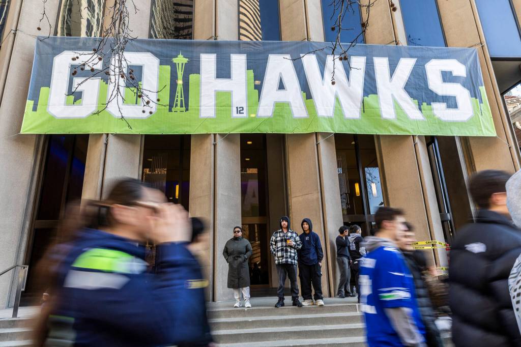 People walk along 4th Avenue before the start of the Seahawks World Champions Parade on Wednesday, Feb. 11, 2026, in Seattle, Washington. (Olivia Vanni / The Herald)