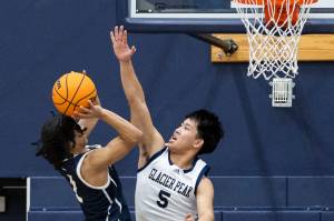 Glacier Peak’s Edison Kan blocks a shot by Arlington’s Mac Crews during the game on Friday, Jan. 16, 2026 in Snohomish, Washington. (Olivia Vanni / The Herald)