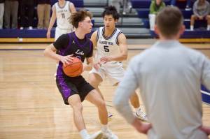 Glacier Peak junior Edison Kan positions himself in front of Lake Washington senior Hunter Phipps during the Grizzlies 60-59 loss to the Kangaroos in the District 1/2 4A semifinals at Glacier Peak High School on Feb. 19, 2026. (Joe Pohoryles/The Herald)