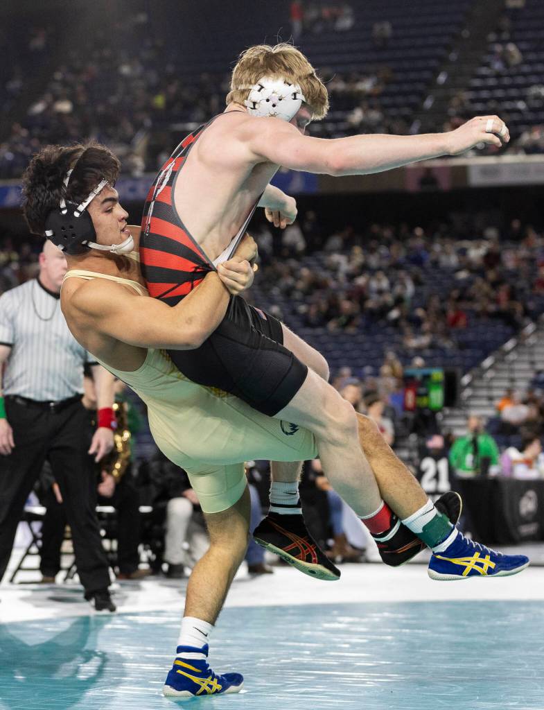 Arlingtons Dayton Fitzgibbon lifts his opponent during the 4A boys 144-pound championship match at the Mat Classic on Friday, Feb. 20, 2026 in Tacoma, Washington. (Olivia Vanni / The Herald)
