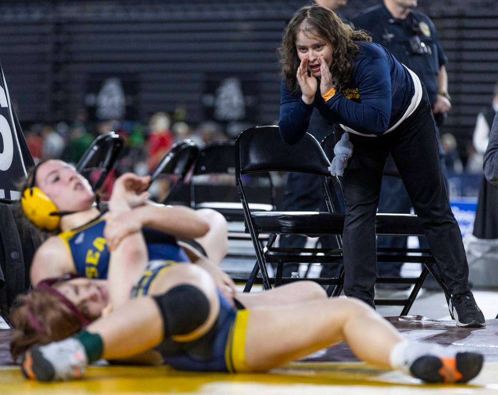 An Everett coach yells instructions to Everetts Caitriona Wieber during the 3A girls 155-pound semifinal match at the Mat Classic on Friday, Feb. 20, 2026 in Tacoma, Washington. (Olivia Vanni / The Herald)
