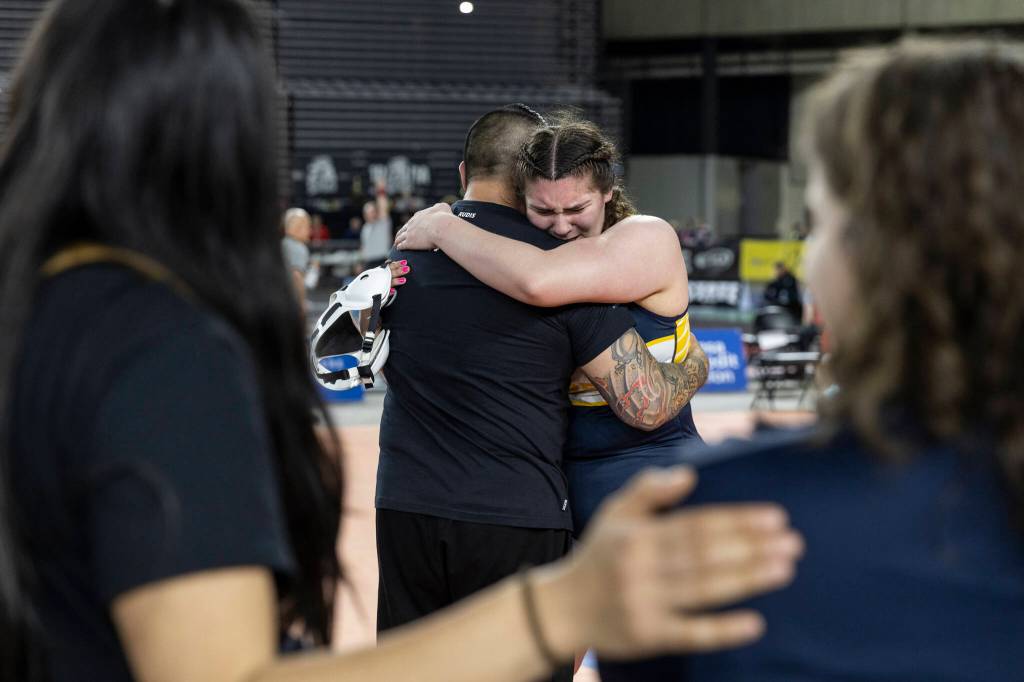 Everetts Mia Cienega hugs her coach after winning the 3A girls 235-pound championship match at the Mat Classic on Friday, Feb. 20, 2026 in Tacoma, Washington. (Olivia Vanni / The Herald)