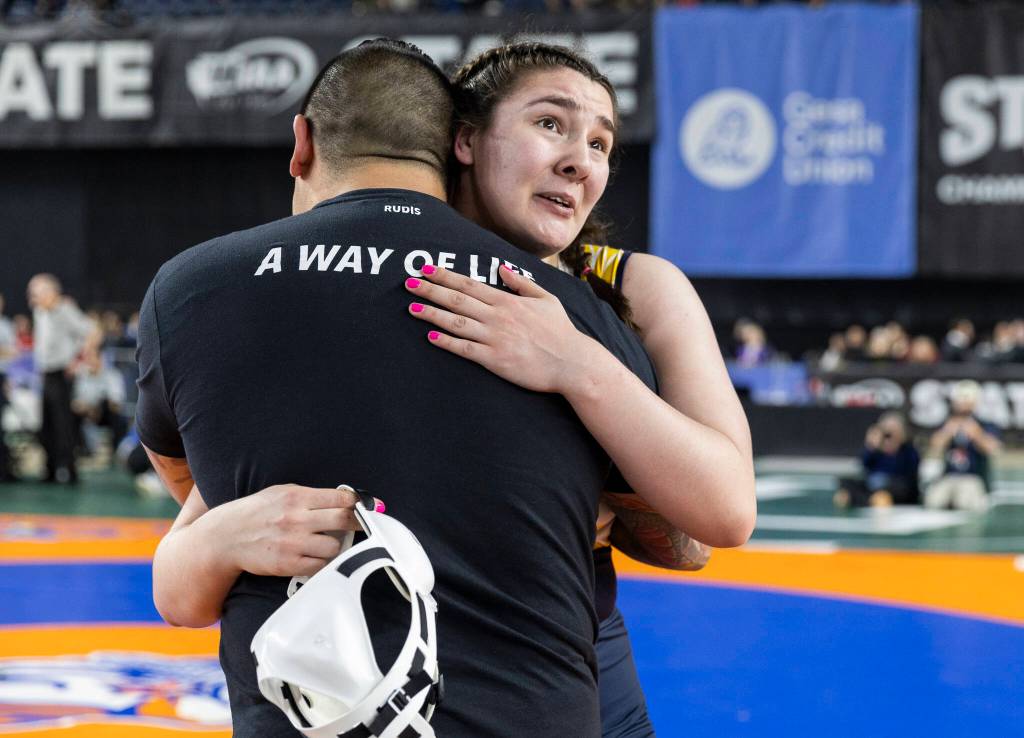 Everetts Mia Cienega hugs her coach after winning the 3A girls 235-pound championship match at the Mat Classic on Friday, Feb. 20, 2026 in Tacoma, Washington. (Olivia Vanni / The Herald)