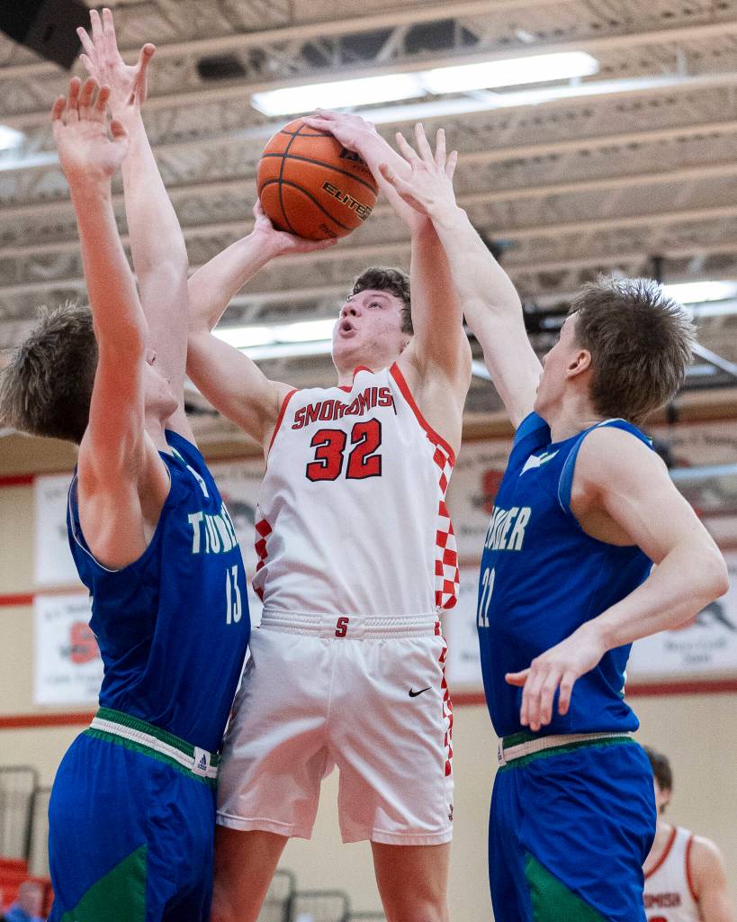 Snohomishs Jack Rotondo tries to take a shot while being defend by Mountain Views Auzzi Ashdown and Patrick Johnson during the 3A state opening round loser-out game on Tuesday, Feb. 24, 2026 in Snohomish, Washington. (Olivia Vanni / The Herald)