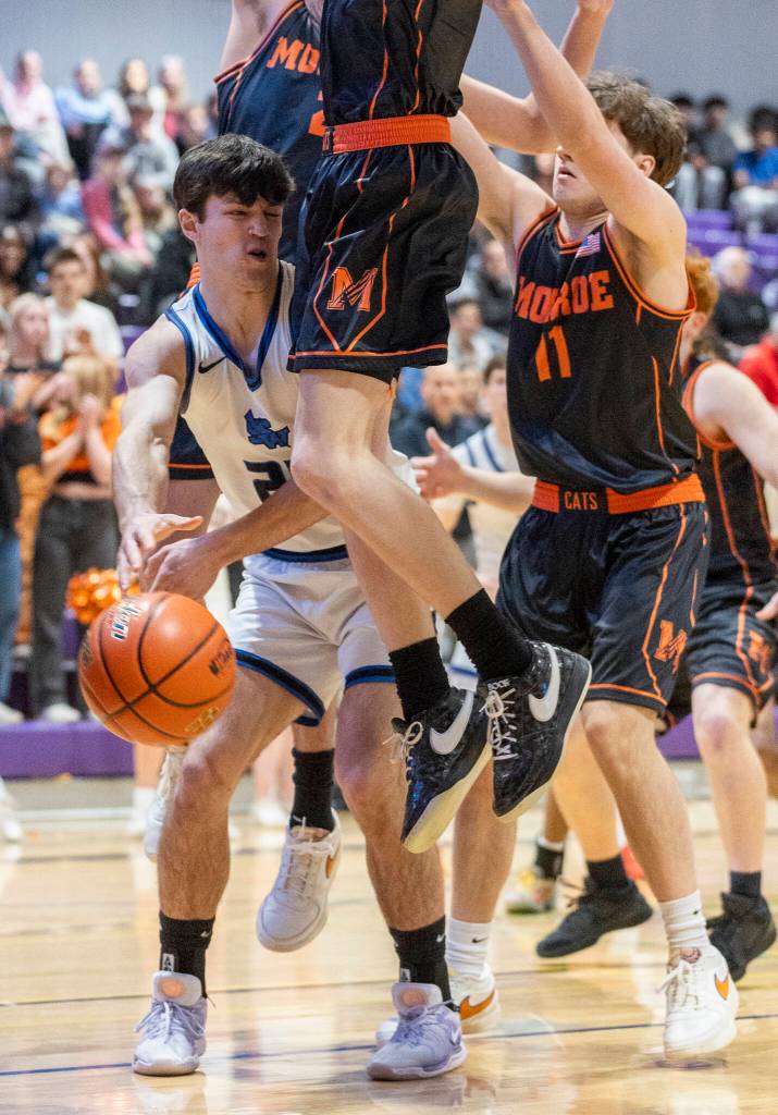 Shorewoods Jaden Marlow passes the ball while Monroe players defend during the 3A state opening round loser-out game on Friday, Feb. 27, 2026 in Bothell, Washington. (Olivia Vanni / The Herald)