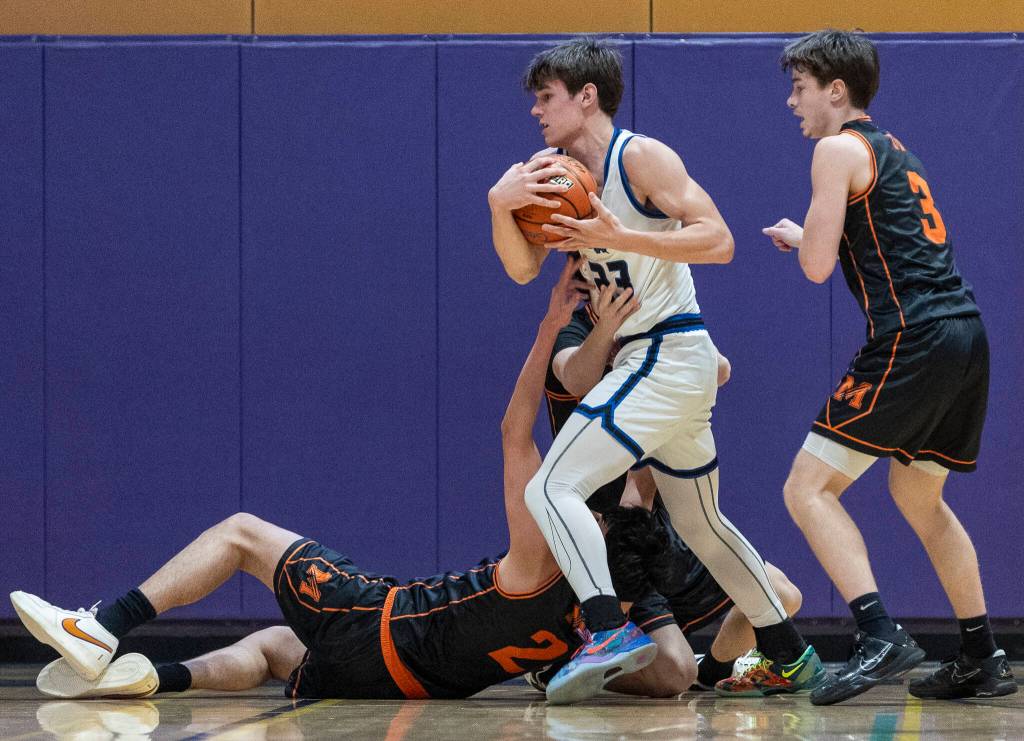Shorewoods Tyler Marlow tries to keep possession while Monroes Dominic Castillo reaches for the ball during the 3A state opening round loser-out game on Friday, Feb. 27, 2026 in Bothell, Washington. (Olivia Vanni / The Herald)