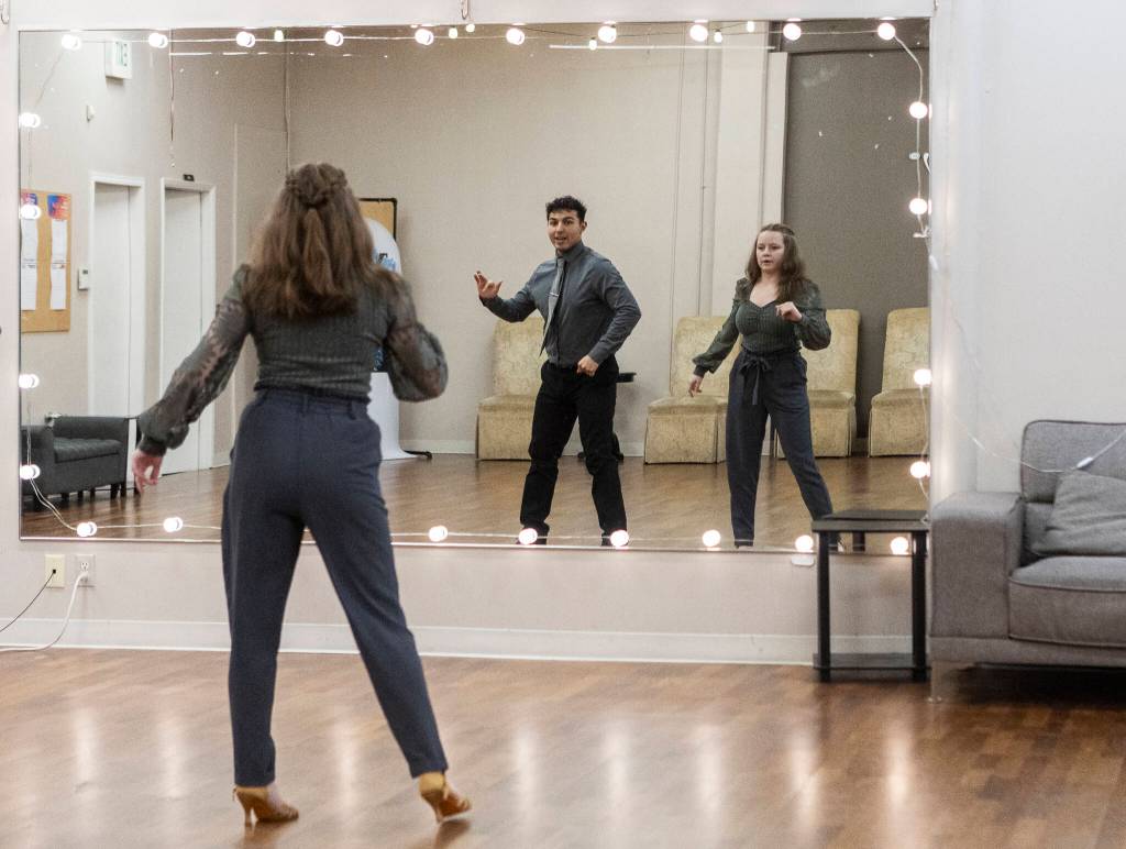 Dance instructor Antonio Samayo and student Alexis Bartsch look in the mirror while they work through a dance at the Arthur Murray Dance Center on Tuesday, Jan. 13, 2026 in Everett, Washington. (Olivia Vanni / The Herald)