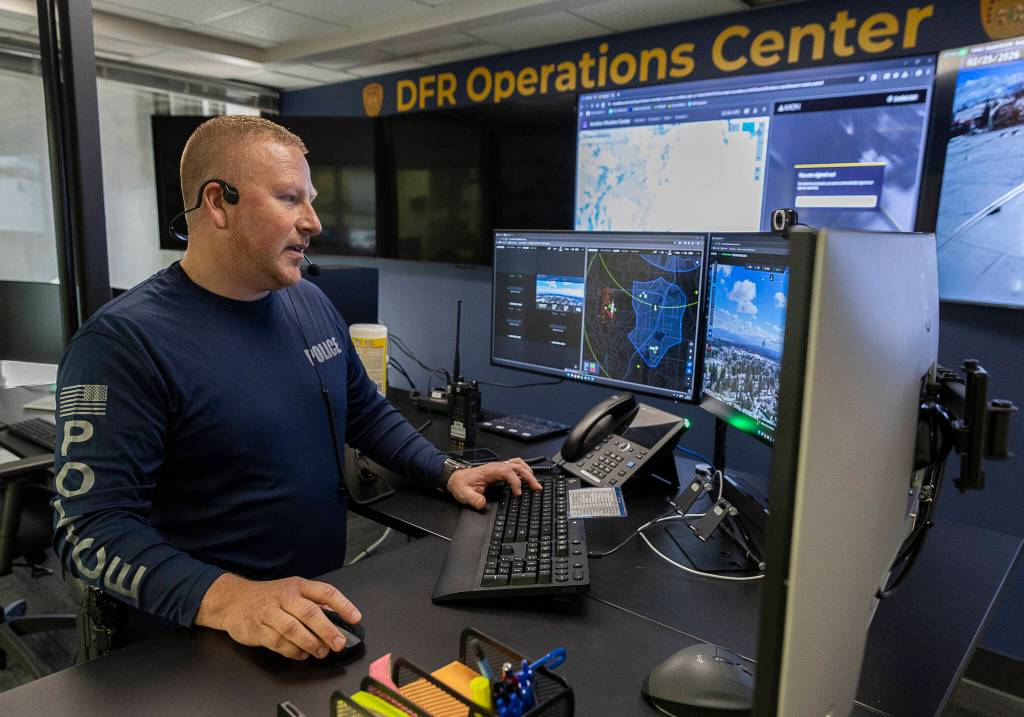 Everett Police Sergeant Robert Edmonds remotely flies one of the police departments drones back to its landing space after responding to a fire call on Feb. 25 in Everett. (Olivia Vanni / The Herald)
