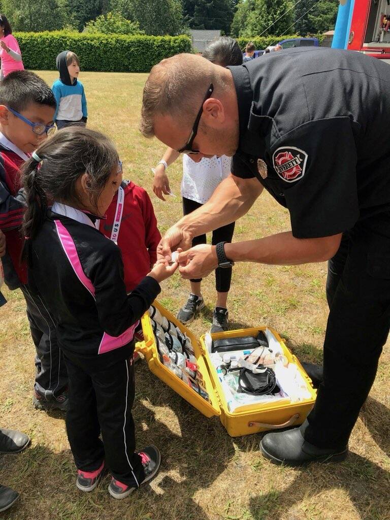 Everett Fire Captain D.J. Neyens works with students at Lowell Elementary School during a field day event. (Photo courtesy of D.J. Neyens)