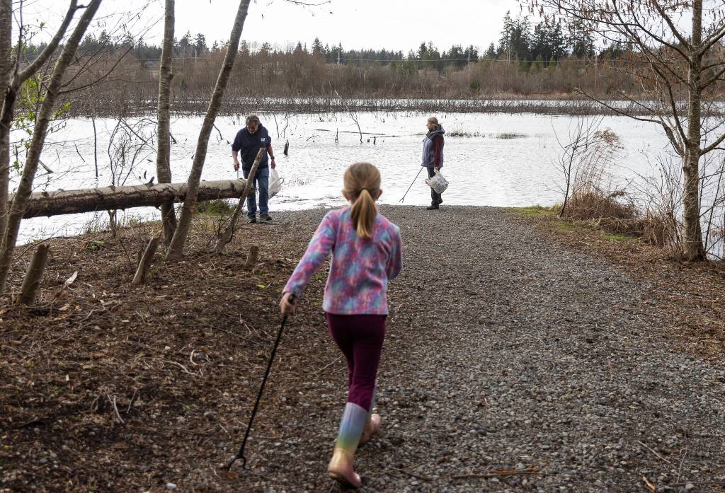 People look for trash in the Penny Creek Natural Area on Friday, March 20, 2026, in Mill Creek, Washington. (Olivia Vanni / The Herald)