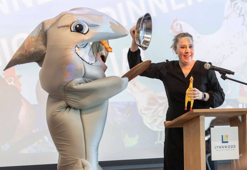 Clark the Shark delivers a tray of rubber chickens to kick off a game of trivia during the State of the City event at the Lynnwood Neighborhood Center on Thursday, March 26, 2026 in Lynnwood, Washington. (Olivia Vanni / The Herald)