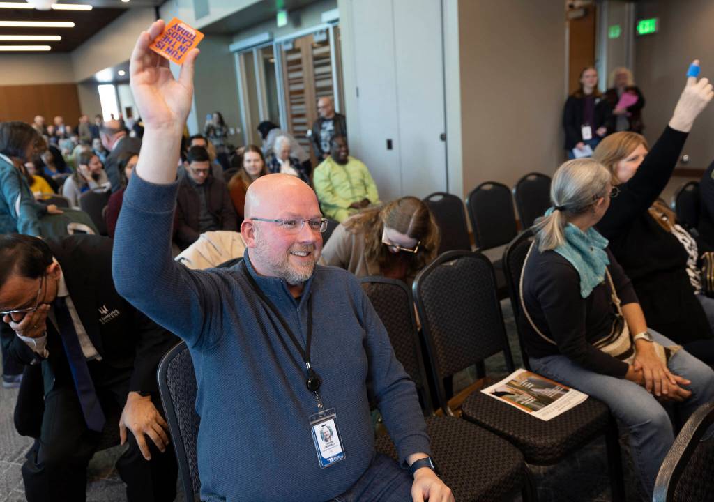 People that found Dave and Busters rewards under their chairs raise their hands during the State of the City event at the Lynnwood Neighborhood Center on Thursday, March 26, 2026 in Lynnwood, Washington. (Olivia Vanni / The Herald)