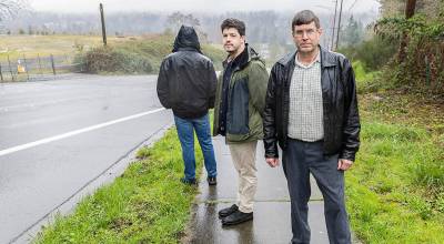 David Irwin, left to right, Robert Endsley and Peter Landry, former Snohomish County Planning and Development Services engineers, stand along 228th Street across from the 228th Street development site on Tuesday, March 24, 2026 in Bothell, Washington. (Olivia Vanni / The Herald)
