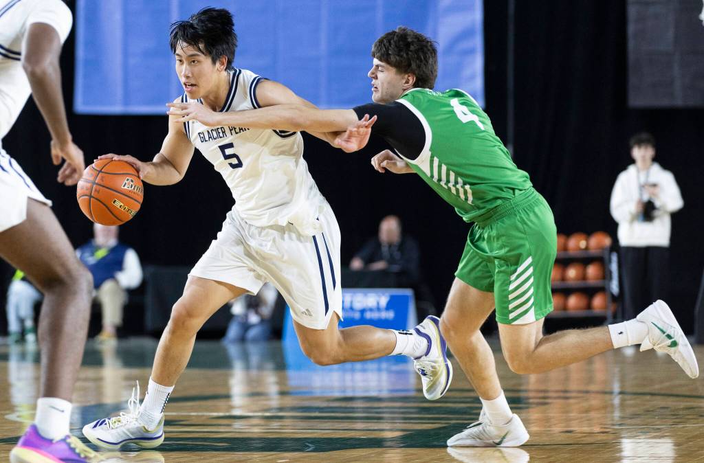 Glacier Peaks Edison Kan dribbles past Woodinvilles Dexter Chastney during the 4A state game on Wednesday, March 4, 2026 in Tacoma, Washington. (Olivia Vanni / The Herald)