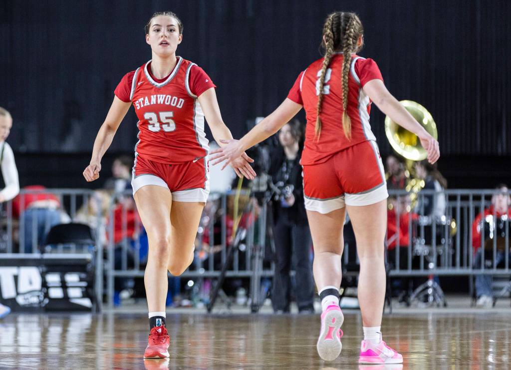 Stanwoods Stella Berrett high fives teammate Ellalee Wortham during the 3A state game against Edmonds-Woodway on Wednesday, March 4, 2026 in Tacoma, Washington. (Olivia Vanni / The Herald)