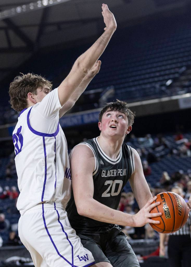 Glacier Peaks Zachary Albright looks to shoot a layup while Lake Washingtons Julien Deblieck defends during the 4A state quarterfinal game on Thursday, March 5, 2026 in Tacoma, Washington. (Olivia Vanni / The Herald)