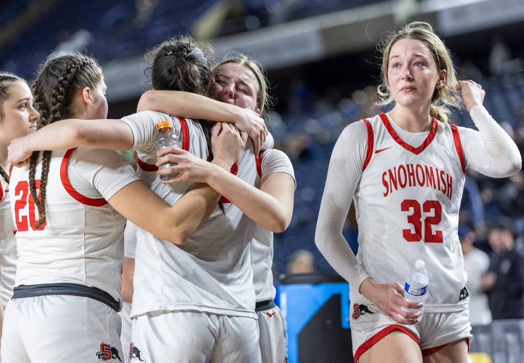 Snohomishs Danica Avalos, Sienna Capelli and Kendall Hammer hug while Lola Rotondo tears up after losing to Eastside Catholic in the 3A state semifinal game on Friday, March 6, 2026 in Tacoma, Washington. (Olivia Vanni / The Herald)