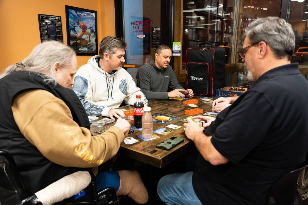 Patrons at Around The Table Game Pub play Terraforming Mars on Jan. 8 in Lynnwood, Washington. (Will Geschke / The Herald)