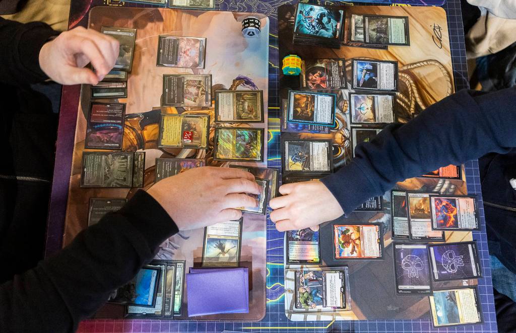 People demonstrate a four player commander-style Magic: The Gathering at Zulu’s Board Game Cafe on Friday, Jan. 9, 2026 in Bothell, Washington. (Olivia Vanni / The Herald)