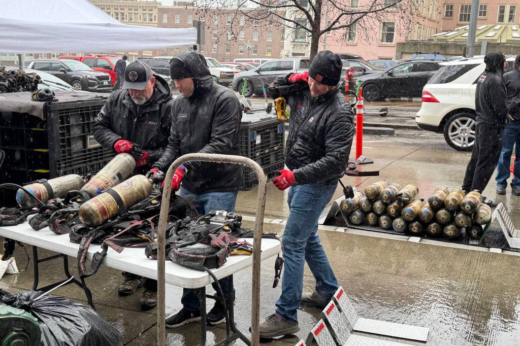 Volunteers work to refill air bottles for firefighters to use at Blood Cancer Uniteds Firefighter Stairclimb on Sunday in Seattle. (Aaron Coe / The Herald)