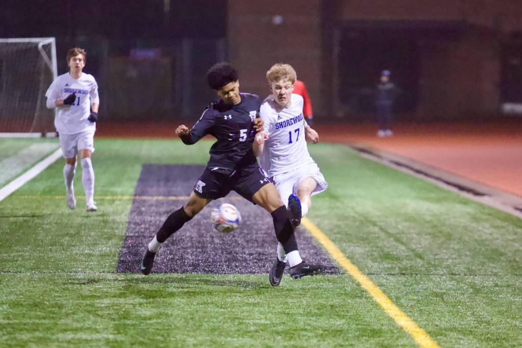 Shorewood junior Julian Shook (right) collides with Kamiak sophomore Jamil Badru while fighting for the ball along the sideline in the Stormrays 3-1 win at Kamiak High School on March 13, 2026. (Joe Pohoryles / The Herald)