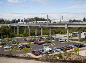 A Link train passes over a parking lot south of the Lynnwood City Center Station in August 2024 in Lynnwood. (Olivia Vanni / The Herald)