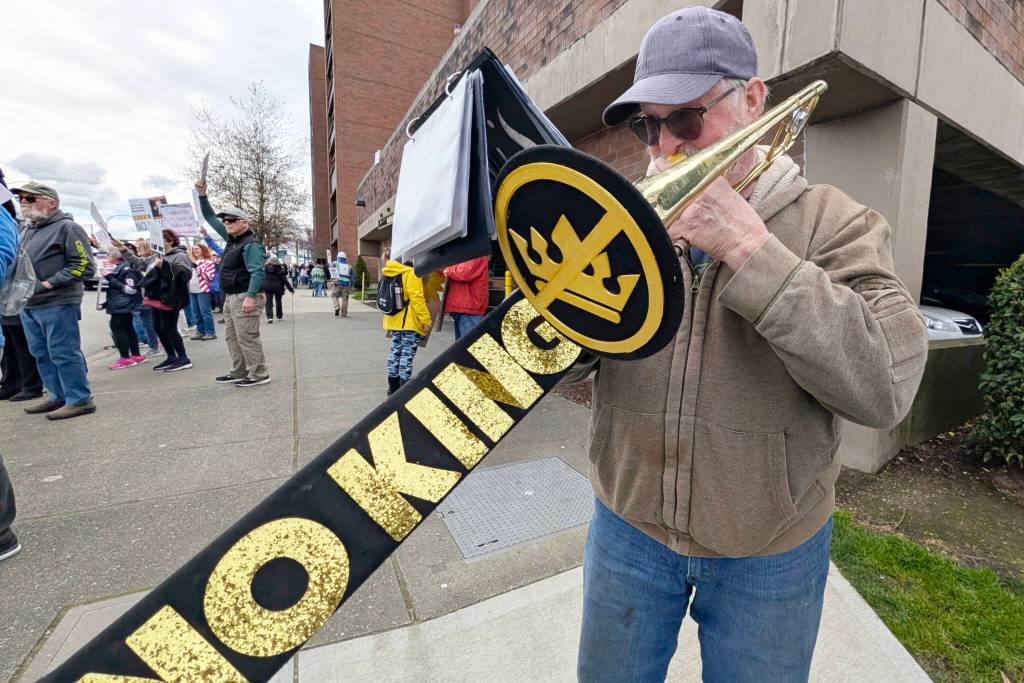Pete Morgan, of Everett, plays a patriotic number with his trombone during a No Kings Day rally on Saturday in Everett. (Michael Henneke / The Herald)