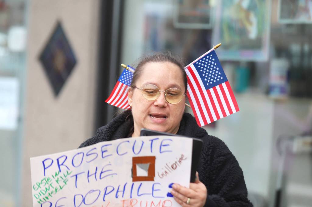 Misty Shaw pauses to check her playlist during a No Kings Day rally on Saturday in Everett. (Michael Henneke / The Herald)