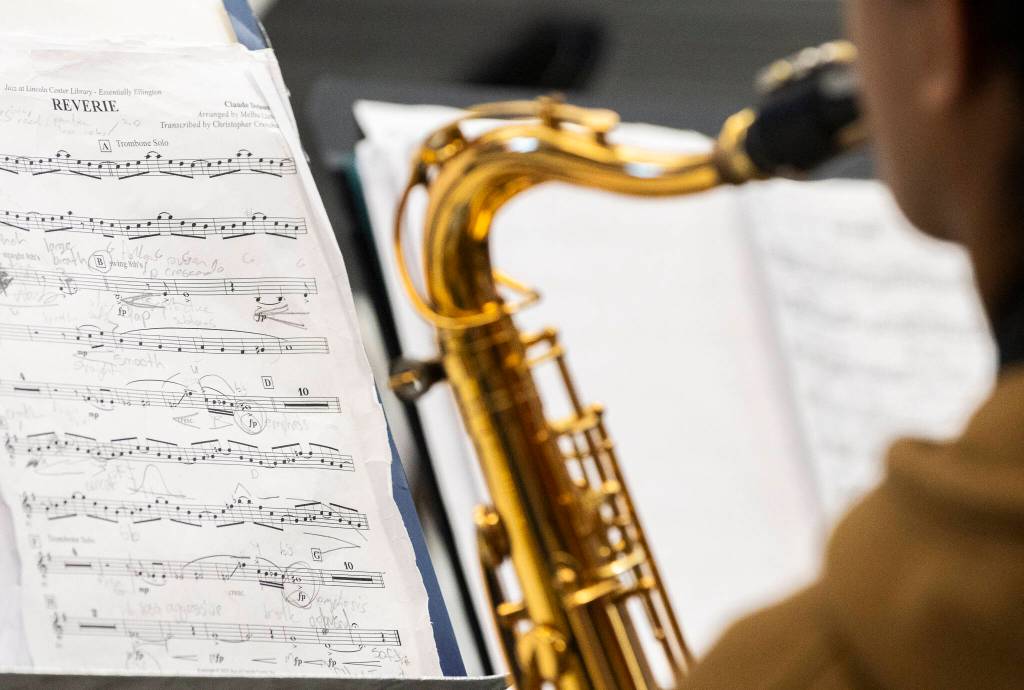 A student plays the saxophone while reading sheet music during a band workshop at Mountlake Terrace High School on Monday, March 30, 2026 in Mountlake Terrace, Washington. (Olivia Vanni / The Herald)