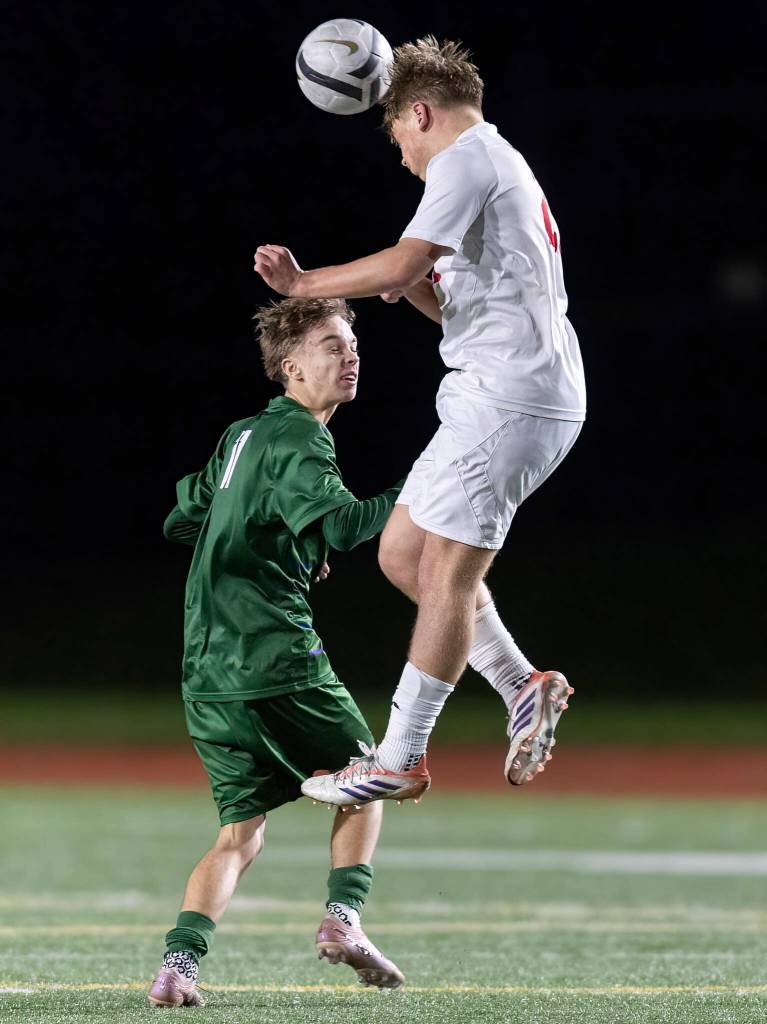 Archbishop Murphys Carter Ward jumps up to head the ball against Edmonds-Woodways Daniel Abraham during the game on Tuesday, March 31, 2026 in Edmonds, Washington. (Olivia Vanni / The Herald)