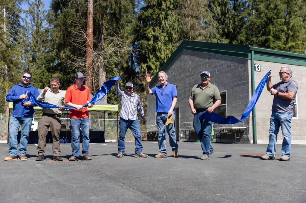 Community members and Granite Falls Wastewater Treatment Plant employees help cut the ribbon celebrating the plant upgrades on Thursday, April 9, 2026, in Granite Falls, Washington. (Olivia Vanni / The Herald)