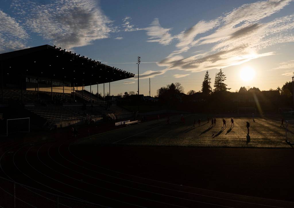 Snohomish and Jackson players cast shadows while they warm up on the field before their game on Monday, April 6, 2026 in Snohomish, Washington. (Olivia Vanni / The Herald)