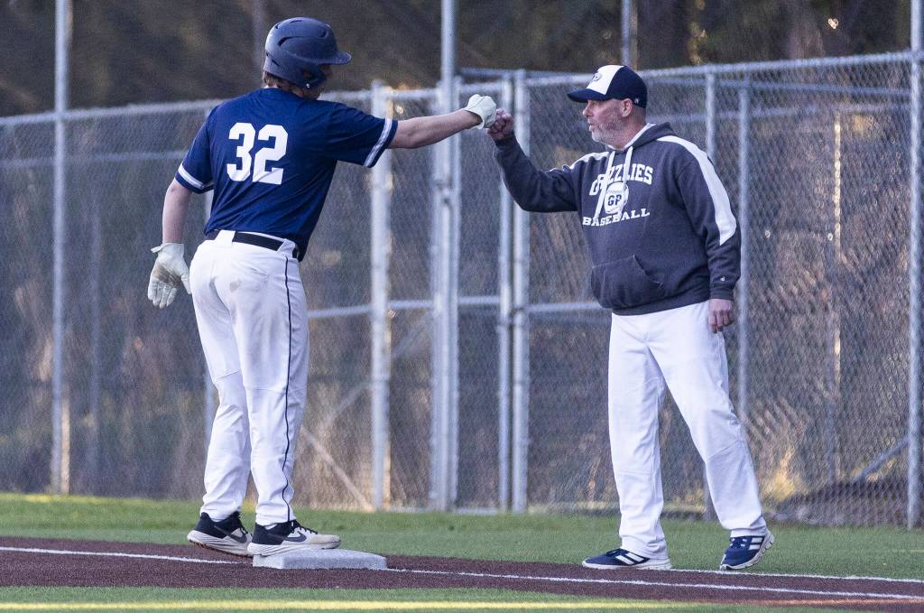 Glacier Peaks Asher Wold fist bumps a coach after getting a hit during the game against Meadowdale on Wednesday, April 8, 2026 in Lynnwood, Washington. (Olivia Vanni / The Herald)