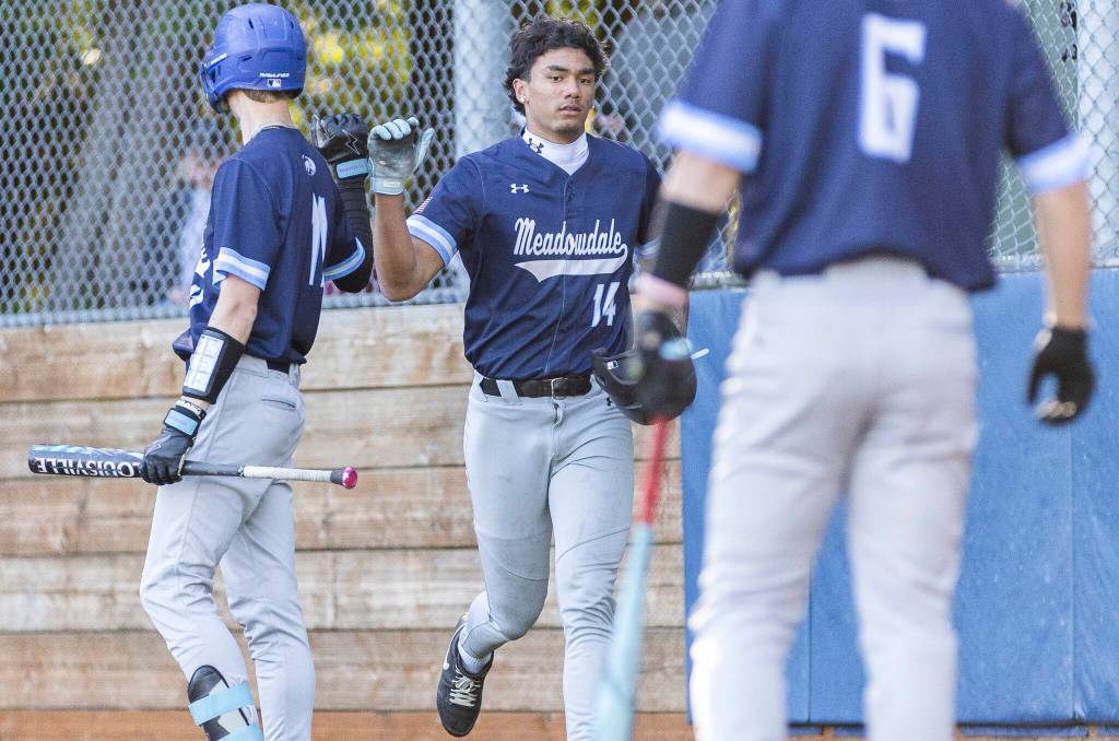 Meadowdales Kealoha Kepoo-Sabate high-fives his teammates after scoring during the game against Glacier Peak on Wednesday, April 8, 2026 in Lynnwood, Washington. (Olivia Vanni / The Herald)