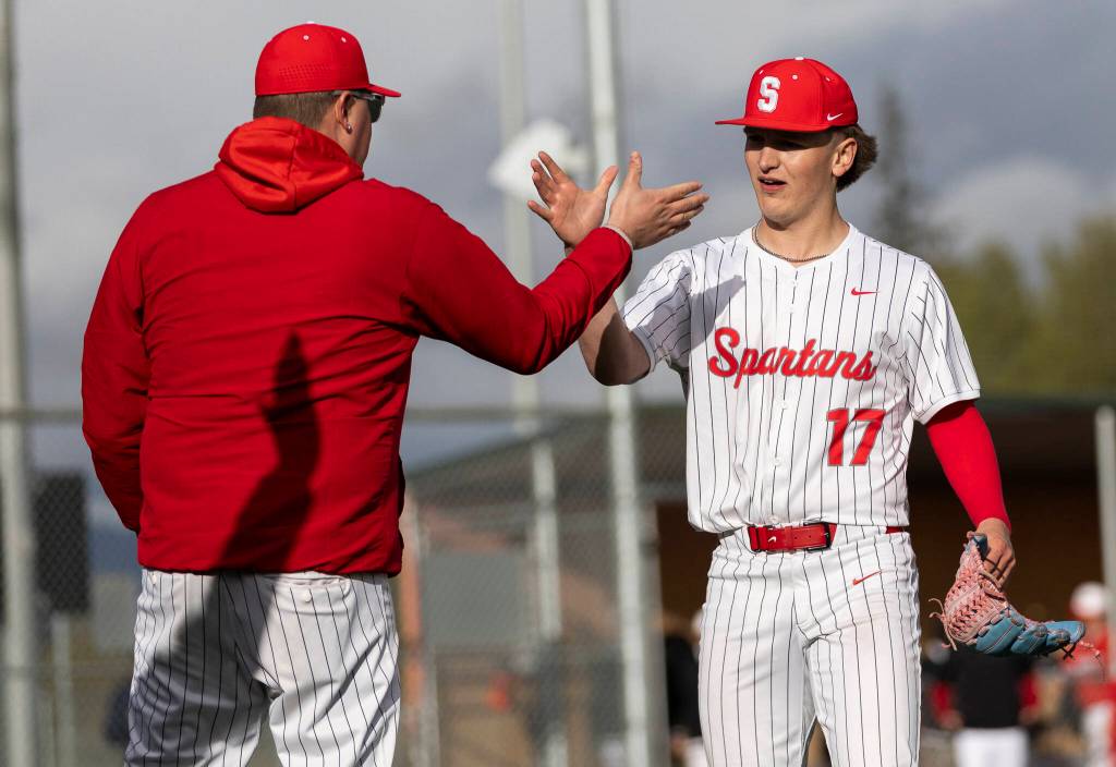 Stanwoods Ryan Hansen high-fives his coach after getting the final out to end the game against Mountlake Terrace on Wednesday, April 15, 2026 in Stanwood, Washington. (Olivia Vanni / The Herald)