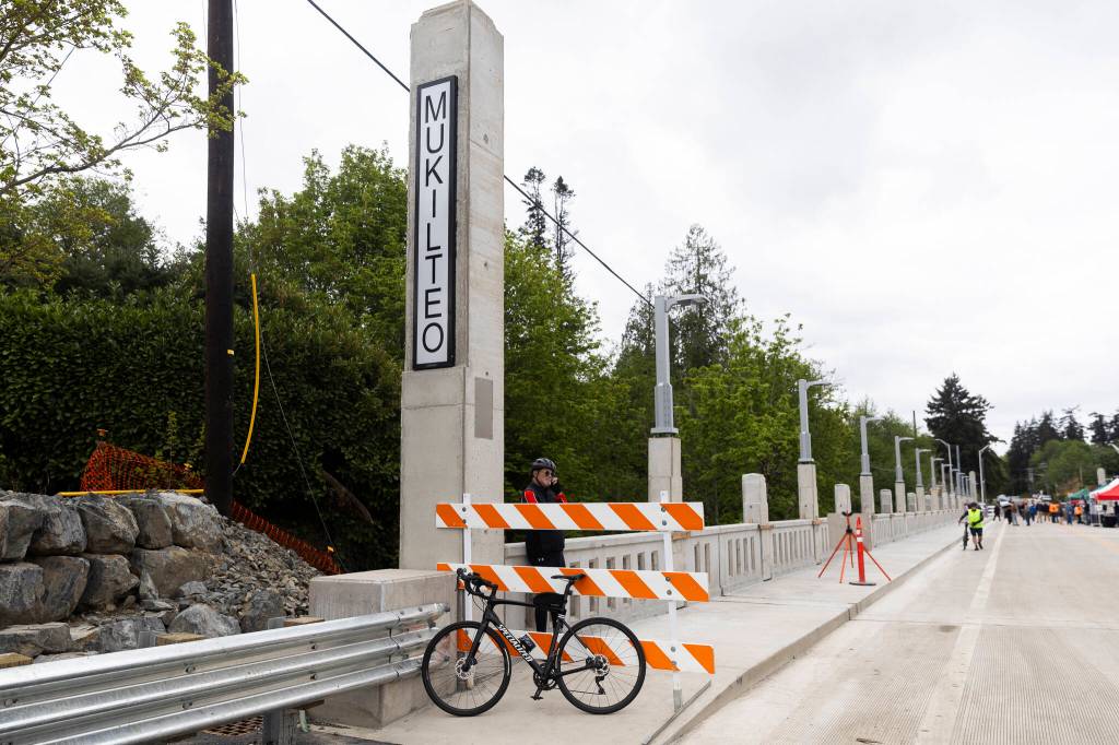 A cyclists waits on the Everett side of the new Edgewater Bridge on Monday, April 27, 2026, in Everett, Washington. (Olivia Vanni / The Herald)