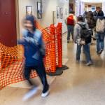 Explorer Middle School students navigate a tight hallway past a recent floor repair that was made due to a leak on Monday, May 11, 2026 in Everett, Washington. (Olivia Vanni / The Herald)