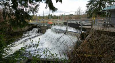 Water tumbles over the top of the Woods Creek Hydroelectric Project and down to a natural waterfall below on Thursday, April 13, 2023, in Monroe, Washington. Tours this year will take place May 15-16. (Ryan Berry / The Herald)